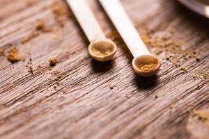 polvo mineral con un dispensador de cuchara para maquillaje sobre fondo de madera foto
