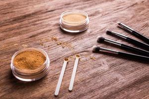 base de polvo mineral con pinceles sobre un fondo de madera. productos de belleza ecológicos y orgánicos foto