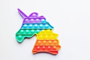 Pop it fidget toy. Multi-colored anti-stress toy with a wing shape on a white background photo