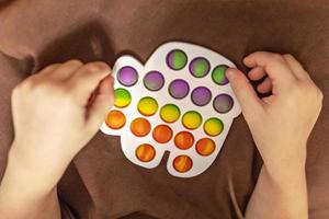 Pop it is a multi-colored anti-stress toy in children's hands. Bubble game. Antistress toys. photo