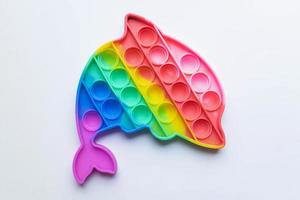 Pop it fidget toy. Multi-colored anti-stress toy with a wing shape on a white background photo