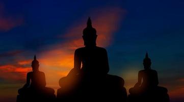 Silhouette of buddhas on golden sunset background buddhism beliefs photo