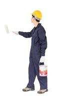 Worker in uniform using paint roller is painting invisible wall photo
