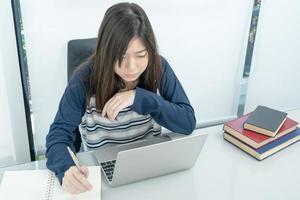 Student sitting in living room and learning online photo