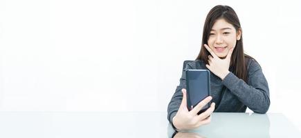 Woman writing notebook and using mobile phone photo