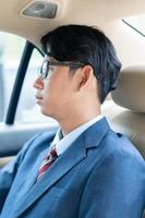 Businessman working in the backseat of a car photo
