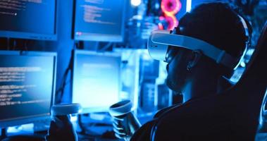 A hacker wearing virtual reality glasses is using computer to hack data to get ransom from victims. photo