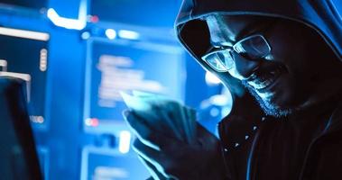 A male hacker is using a computer to hack data to demand ransom from victims. photo