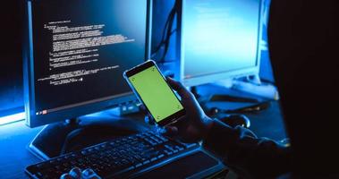 A male hacker is using a computer to hack data to demand ransom from victims. photo