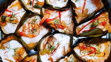 Steamed fish and shrimp curry in banana leaf cup on steamer pot. Famous food in Thailand using mixture of Thai spices curry and many herb with chili, coconut milk, galangal, garlic, kaffir lime leaf. photo