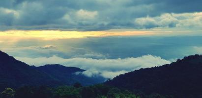 Beautiful landscape view of green mountain with forest, mist or foggy and sunlight in morning at Phetchabun province, Thailand. Cloudscape on hills on new day. Landmark for travel and Good air fresh. photo