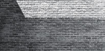 pared de ladrillo con sombra de fondo en tono blanco y negro. papel tapiz de arte y patrón en estilo monocromo. loft, diseño exterior o interior áspero y grunge con espacio de copia foto