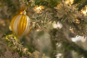 adorno de oro en el árbol de navidad con fondo de vacaciones de nieve foto