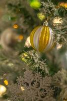 Gold bauble and snowflake on Christmas tree holiday background photo