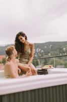 pareja joven disfrutando en el jacuzzi al aire libre de vacaciones foto