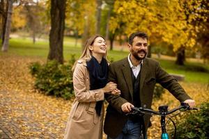 pareja joven, en, el, otoño, parque, con, bicicleta eléctrica