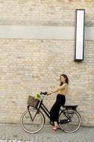 mujer con flores en la cesta de la bicicleta eléctrica foto