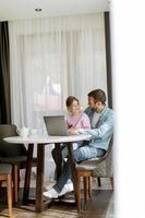 Father and daughter using laptop computer together photo