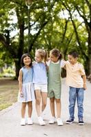 grupo de niños asiáticos y caucásicos divirtiéndose en el parque foto