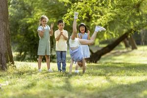 grupo de niños asiáticos y caucásicos divirtiéndose en el parque foto