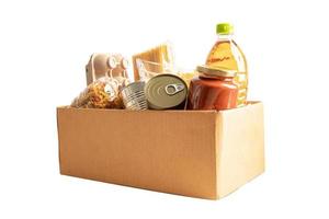 alimentos para donación, almacenamiento y entrega. varios alimentos, pasta, aceite de cocina y alimentos enlatados en caja de cartón. foto