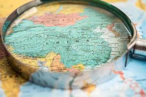 Bangkok, Thailand - May 01, 2022 China, Magnifying glass close up with colorful world map. photo