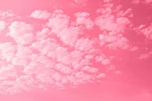 Beautiful cirrus white clouds on the pink sky, copy space natural background. Image toned in color of the year 2023 viva magenta. photo