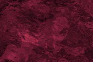 Texture of water surface with ripples and reflectionts toned by trendy Viva Magenta color 2023 year. photo