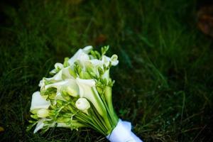 hermosa decoración de bodas con diferentes hojas verdes exóticas de rees para el concepto de naturaleza conjunto de hojas. ramo delicado. ramo de rosas, peonías, calas para la novia y el novio de la boda foto