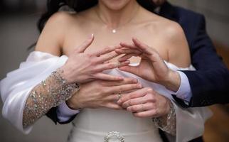 manos de la novia y el novio con anillos. novia y novio en un café. mesa de ramo de boda. la novia y el novio se dan la mano. anillos de boda. pareja amorosa en un café. té caliente para los amantes foto