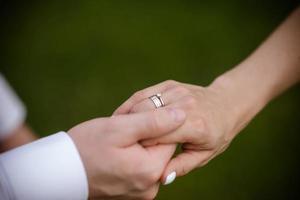 hands of bride and groom with rings. bride and groom in a cafe. wedding bouquet table. bride and groom hold each other's hands. Wedding rings. Loving couple in a cafe. hot tea for lovers photo