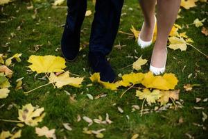 foots of bride and groom . The bride and groom holding on hands and walking on road in the nature. Outdoors. Down view at shoes. photo