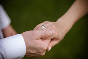 hands of bride and groom with rings. bride and groom in a cafe. wedding bouquet table. bride and groom hold each other's hands. Wedding rings. Loving couple in a cafe. hot tea for lovers photo