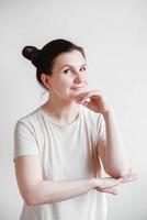 Beautiful woman with pigtails and a funny face wearing a T-shirt on a white background. Copy, empty space photo