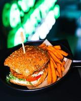 hamburguesa con queso en sartén con fondo negro foto