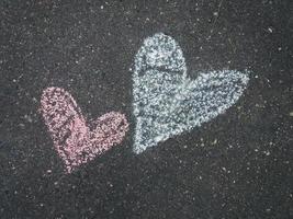 dos corazones dibujados con tiza en el asfalto, cerrados