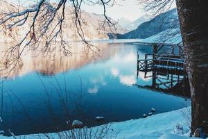 lago de montaña en invierno, casa del muelle bajo la nieve foto