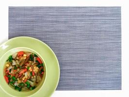 Simple vegetable soup in green bowl,  gray placemat, top view, copy space photo