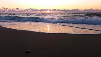 mar tormentoso por la noche, nubes bajas, sol poniente sobre el báltico al final del día ventoso foto