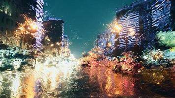 Blurry city lights at rainy night - view of evening traffic through wet windscreen, vibrant cityscape photo