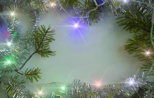 Christmas background. Christmas tree branches, light garland and tinsel. photo