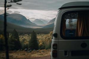 una autocaravana retro está estacionada en un lugar hermoso y apartado al aire libre. tiene un pequeño toldo y las ventanas están abiertas, invitando a los aventureros a explorar. la esencia de la vida en furgoneta. foto