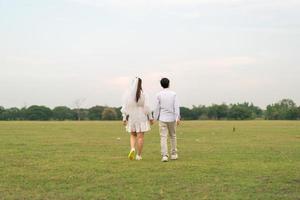 Happy young Asian couple in bride and groom clothing photo