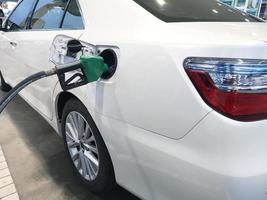 Pistola de bomba de boquilla verde gasolina de la bomba de aceite en el tanque del coche foto