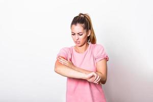 Women scratch the itch with hand , Concept with Healthcare And Medicine. Woman scratching arm on grey background. Allergy symptoms. Woman scratching her arm. photo