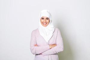 retrato de una joven musulmana árabe con una sonrisa de pañuelo en la cabeza. primer plano de retrato de una mujer musulmana de 20 años con hiyab sonriendo aislada sobre fondo blanco. foto