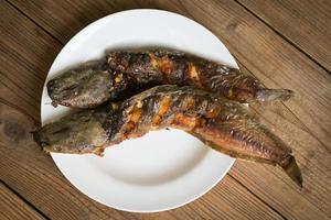 bagre a la parrilla en un plato blanco, comida tailandesa cocinando bagre pescado de agua dulce foto