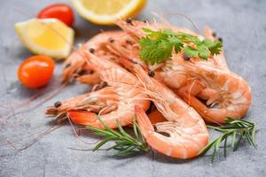 fresh shrimp on dark plate with ingredients herb and spices - cooking seafood shrimps prawns served on a table background photo