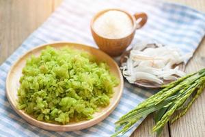 postre tailandés - arroz inmaduro machacado copos de arroz cereal con coco y azúcar, arroz verde dulce con orejas de hoja de pandan de arroz, postre de comida o bocadillos - nombre khao mao en tailandia foto