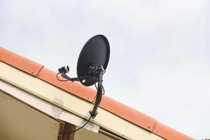 antenas de televisión por satélite en el techo de la casa - comunicación por plato foto